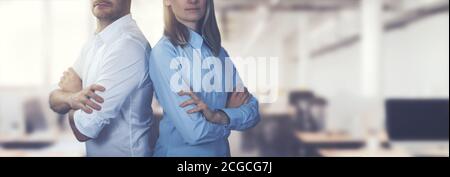 Junge Geschäftsleute paar posiert mit Armen gekreuzt auf Bürohintergrund. Platz kopieren Stockfoto