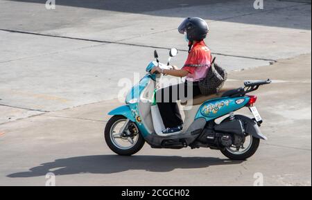 SAMUT PRAKAN, THAILAND, JUNI 26 2020, Frau mit Helm fährt ein Motorrad Stockfoto