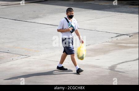 SAMUT PRAKAN, THAILAND, JUNI 26 2020, EIN Junge in Schuluniformen geht mit Plastiktüte auf die Straße. Stockfoto