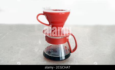 Pourover. V60. Frischer, heißer Kaffeefilter tropft in den Glasserver Stockfoto