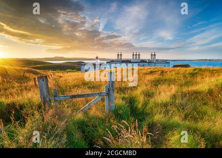 Sonnenuntergang über den alten Küstenschutzhütten am Arnish Point On Der Eingang zum Hafen von Stornoway auf der Isle of Lewis In den Äußeren Hebriden Stockfoto