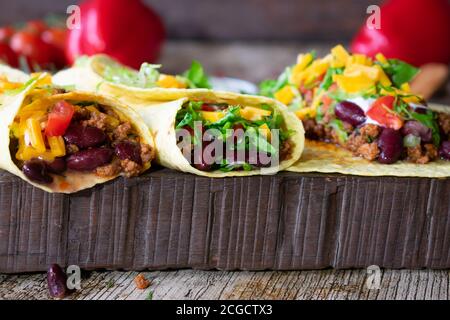 Hausgemachte Burritos mit Hackfleisch und Kidney Bohnen auf einem Rustikales Holzbrett - bereit zu essen Stockfoto