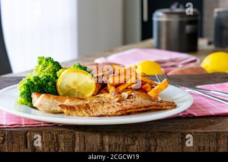 Fisch mit Süßkartoffeln und Brokkoli auf einem Teller Stockfoto