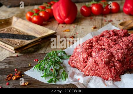Frisches und rohes Hackfleisch, Hackfleisch aus einem Metzger auf Holztisch Hintergrund Stockfoto