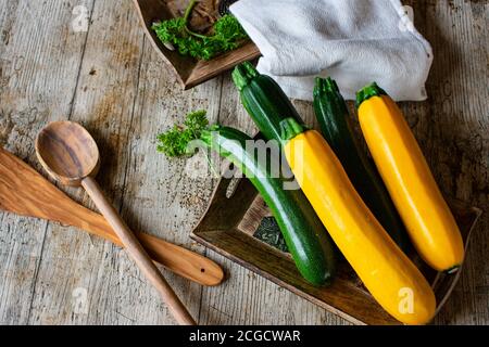 Grüne Zucchini und gelbe Zucchini auf Holztisch Stockfoto