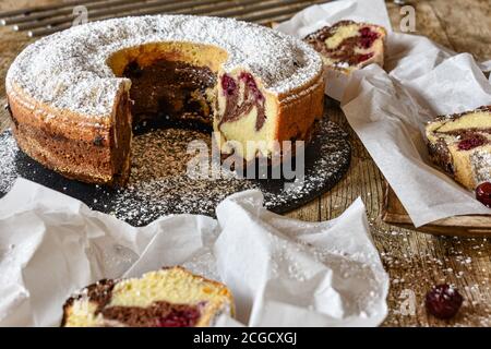 bunt Marmor fröhliche Kuchen auf einem schwarzen Teller serviert Ein Holztisch - frisch und hausgemacht - bereit zu Essen Stockfoto