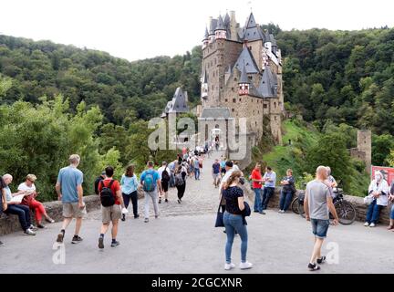 Cochem, Deutschland, 9. September 2020: Urlaub zu Hause: Aufgrund der durch die Corona-Krise verursachten Auslandsreisebeschränkungen verbringen viele Deutsche ihren Urlaub im eigenen Land. Besucher stehen am Eingang zur Burg Eltz in Rheinland-Pfalz, zu der nicht mehr als 200 Personen zugelassen sind und Wartezeiten von mehr als einer Stunde akzeptieren Stockfoto