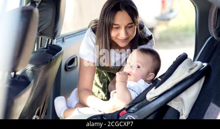 Kleines Baby in einem Autositz im Auto. Gerader Schuss. Das Kind schaut auf die Kamera. Stockfoto