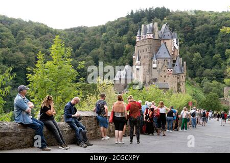 Cochem, Deutschland, 9. September 2020: Urlaub zu Hause: Aufgrund der durch die Corona-Krise verursachten Auslandsreisebeschränkungen verbringen viele Deutsche ihren Urlaub im eigenen Land. Besucher stehen am Eingang zur Burg Eltz in Rheinland-Pfalz, zu der nicht mehr als 200 Personen zugelassen sind und Wartezeiten von mehr als einer Stunde akzeptieren Stockfoto