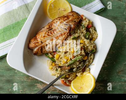 Natürliche Pfanne gebratenen Fisch mit braunem Reis und Gemüse Stockfoto