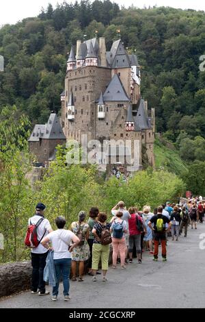 Cochem, Deutschland, 9. September 2020: Urlaub zu Hause: Aufgrund der durch die Corona-Krise verursachten Auslandsreisebeschränkungen verbringen viele Deutsche ihren Urlaub im eigenen Land. Besucher stehen am Eingang zur Burg Eltz in Rheinland-Pfalz, zu der nicht mehr als 200 Personen zugelassen sind und Wartezeiten von mehr als einer Stunde akzeptieren Stockfoto