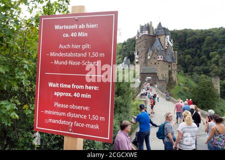 Cochem, Deutschland, 9. September 2020: Urlaub zu Hause: Aufgrund der durch die Corona-Krise verursachten Auslandsreisebeschränkungen verbringen viele Deutsche ihren Urlaub im eigenen Land. Besucher stehen am Eingang zur Burg Eltz in Rheinland-Pfalz, zu der nicht mehr als 200 Personen zugelassen sind und Wartezeiten von mehr als einer Stunde akzeptieren Stockfoto