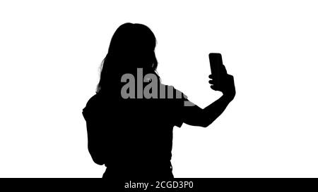 Silhouette fröhliche weibliche blogger Video beim Gang zur Kamera an der Vorderseite des modernen Telefon. Stockfoto