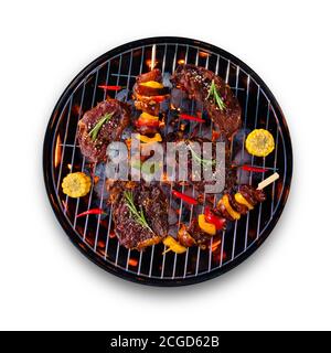 Frische rohe Rindersteaks und Spieße mit Gemüse auf dem Grill platziert, isoliert auf weißem Hintergrund. Kochen, Zubereitung und Grillzubehör. Stockfoto