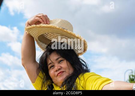 Eine Asiatin mittleren Alters, Mitte 50, mit Strohhut. Stockfoto