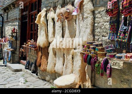 Lahic. Eine Ausstellung von traditionellen aserbaidschanischen Andenkenhüten, Taschen, Stricksocken und Schaffellpelzen an der Hauptstraße von Lahic, einem Hochlanddorf in Aserbaidschan. Stockfoto