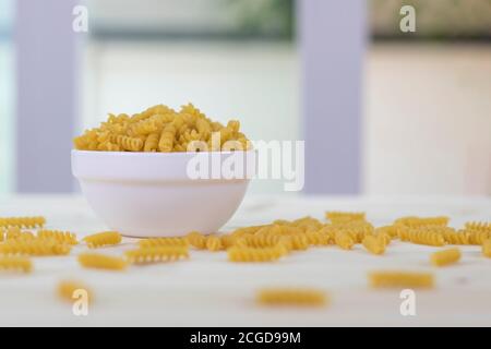 Fusilli in weißen Tassen auf einem Holztisch platziert. Stockfoto