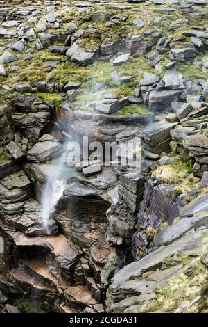 Ein starker Westwind verursacht Wasser fließt über Kinder Sturz wieder zu sprühen. Kinder Scout, Derbyshire, Peak District National Park, England, Großbritannien Stockfoto
