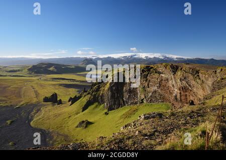 Der schwarze Sand von Dyrholaey Beach, von den Klippen von Dyrholaey aus gesehen. Die weiße Mütze von Myrdalsjokull ist in der Ferne zu sehen. Südisland. Stockfoto