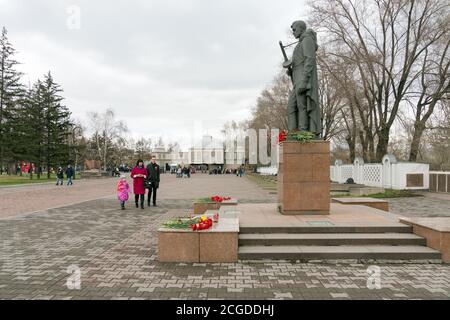 Die Menschen gehen zum Alesha Denkmal für die Soldaten der Der zweite Weltkrieg auf dem Hintergrund des Siegedenkmals in der Krasnojarsk Stadt Stockfoto