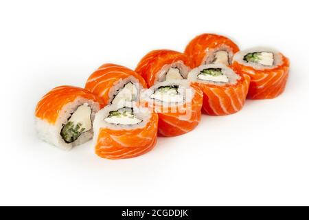 Sushi-Rolle Philadelphia mit Gurke auf einem weißen Teller, klassisches japanisches Sushi. Traditionelles japanisches Essen mit Maki. Leckere Sushi-Stücke. Für das Restaurant-Menü. Copyspace. Stockfoto