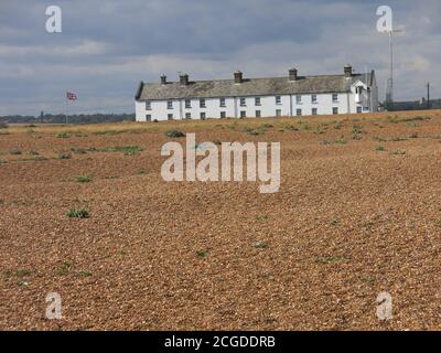 Eine Reihe von ehemaligen Küstenschutzhütten an der Shingle Street, einem isolierten Weiler an den düsteren Schindelbänken von Suffolk. Stockfoto
