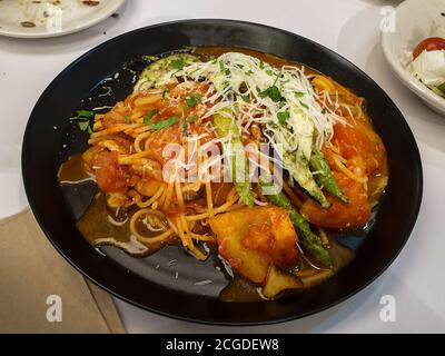 Spaghetti mit frischer Tomatensauce. Gegrillter Spargel, Zucchini, Auberginen. Garniert mit frischem Mozzarella-Käse und Basilikum-Pesto. Stockfoto