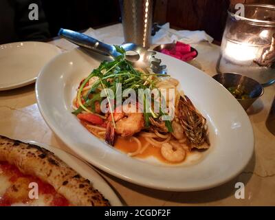 Pasta Spaghetti mit gegrillten Garnelen, Rucola und Tomatensauce gekocht. Berühmtes und gemütliches italienisches Restaurant in Seoul, Südkorea. Romantische Atmosphäre. Stockfoto
