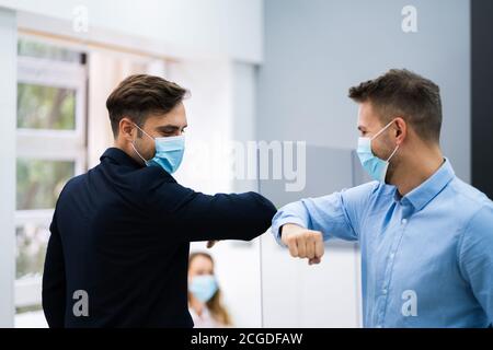 Mitarbeiter, Die Elbow Bump Machen, Um Grippe Zu Vermeiden Und Covid Zu Stoppen Verteilen Stockfoto