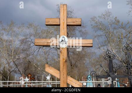 Holzkreuz auf dem Hintergrund der Frühlingsbäume auf dem Troizker Friedhof der Stadt Krasnojarsk. Russland. Stockfoto