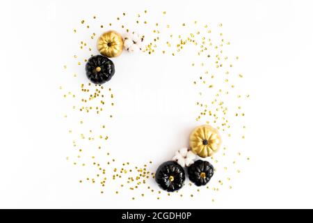 Goldrahmen verziert mit schwarzem und goldenem Halloween Kürbis und Lametta mit Platz für Text. Isoliert auf weißem Hintergrund. Flach liegend, Draufsicht. Stockfoto