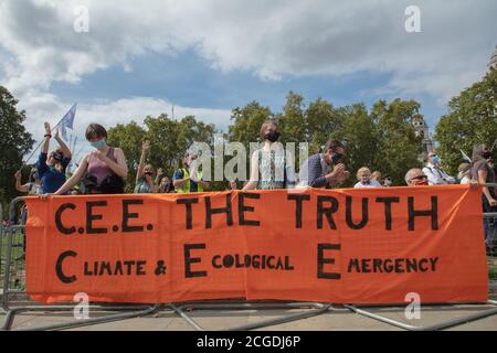 London, Großbritannien. September 2020. Mitglieder der Extinction Rebellion Climate Change Action Group hinter einem großen orangefarbenen Banner mit Schild auf dem Parliament Square während ihrer Protestaktionen gesehen. Quelle: Joe Kuis / Alamy News Stockfoto