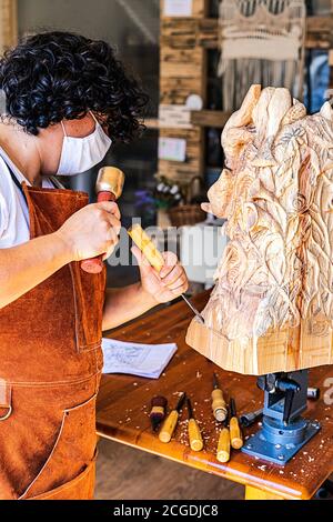 Bildhauerin mit Maske Schnitzerei Holzfigur Stockfoto