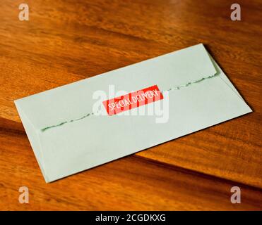 Mintgrüner Umschlag mit rotem Sonderstempel auf Nussbaum Holz Stockfoto