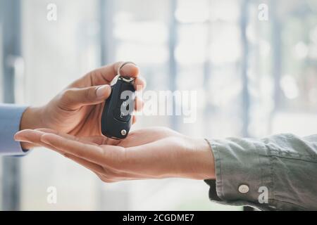 Geschäftskonzept, Kfz-Versicherung, Auto verkaufen und kaufen, Kfz-Finanzierung, Kfz-Schlüssel für Kfz-Kaufvertrag. Neue Besitzer nehmen Schlüssel von männlichen Salespe Stockfoto