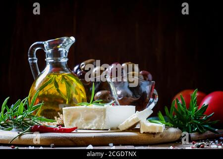 Weicher griechischer Feta-Käse mit Rosmarin, Oliven und Butter, selektiver Fokus Stockfoto