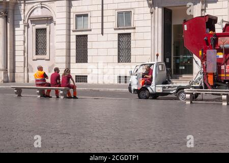 Rom, Italien - 28. Juni 2010: Arbeiter der öffentlichen Müllabfuhr in Rom sitzen auf einer Bank auf der Piazza Navona. Stockfoto