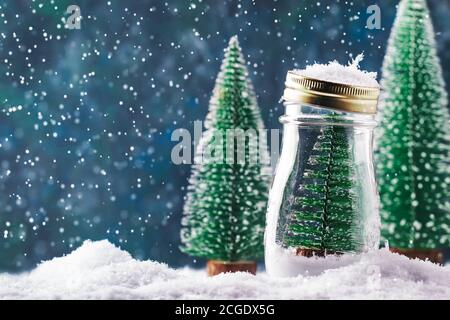 Kleiner Weihnachtsbaum in einem Glas, Silvester verschneiten Hintergrund, Weihnachtskonzept Stockfoto