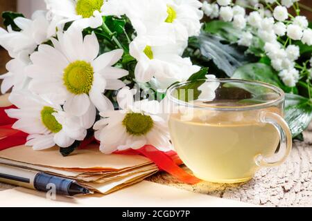 Kräutertee, ein Bouquet von Gänseblümchen, altes Papier, selektiver Fokus Stockfoto