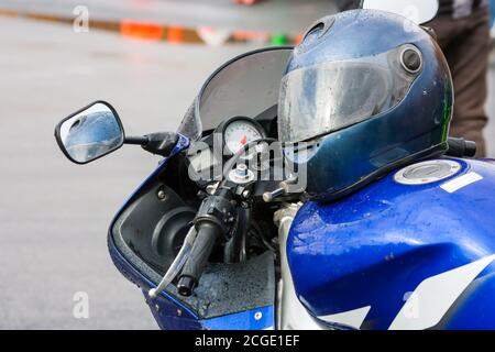Helm auf einem Motorrad im Regen Stockfoto