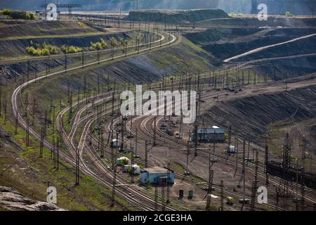 Tagebaugewinnung von Kohle im Steinbruch "Bogatyr", Ekibastuz, Kasachstan. Güterbahn und Masten. Stockfoto