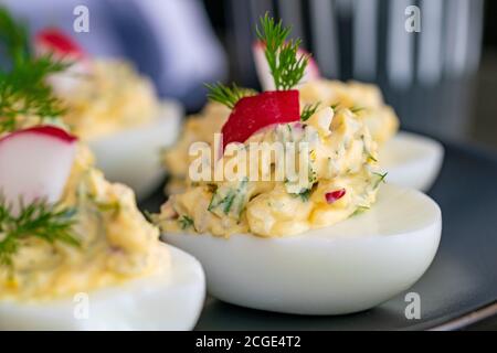 Frisch zubereitete gekochte Eier gefüllt mit Mayo, Zwiebeln, Ei und Rettich garniert mit Dill. Stockfoto