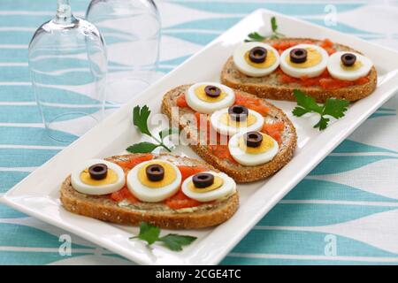 Swedish Open Sandwich mit in Scheiben geschnittenem gekochtem Ei, schwarzen Oliven und Dill auf gewürztem Kabeljau Roggenbrot. Stockfoto