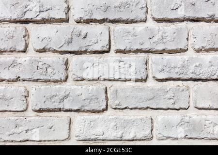 Hintergrund und Textur einer alten Ziegelwand weiß gemalt, Nahaufnahme. Stockfoto