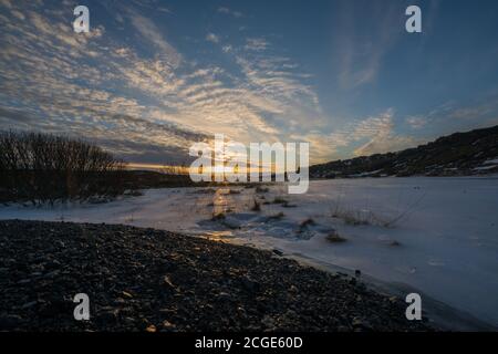 Gefrorener flacher See im Þingvellir Nationalpark bei Sonnenuntergang Stockfoto