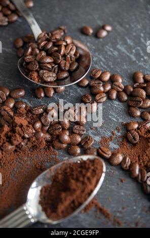 Löffel auf einem Tisch mit Kaffeebohnen und Kaffeepulver Stockfoto