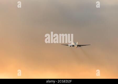 Silhouette des Flugzeuges, das während eines dramatischen Sonnenuntergangs Himmel, kopieren Raum abheben. Luftfahrt. Stockfoto