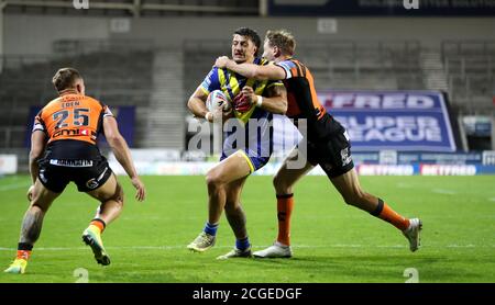 Anthony Gelling von Warrington Wolves (Mitte) wird von Michael Shenton von Castleford Tigers während des Betfred Super League-Spiels im Totally Wicked Stadium, St. Helens, angegangen. Stockfoto