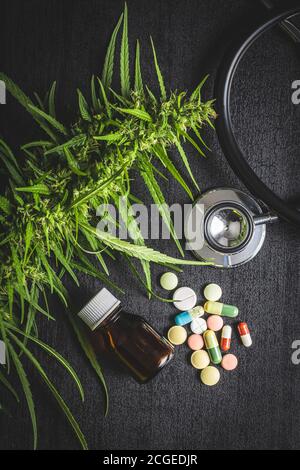 Marihuana Knospen Blüten von Cannabis, Stethoskop, Pillen und Öl auf Balcktisch. Draufsicht. Stockfoto