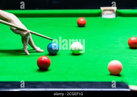 Ein Mann spielt Snooker in der Bar. Snooker-Spieler mit Snooker-Ball auf Snooker-Tisch. Stockfoto